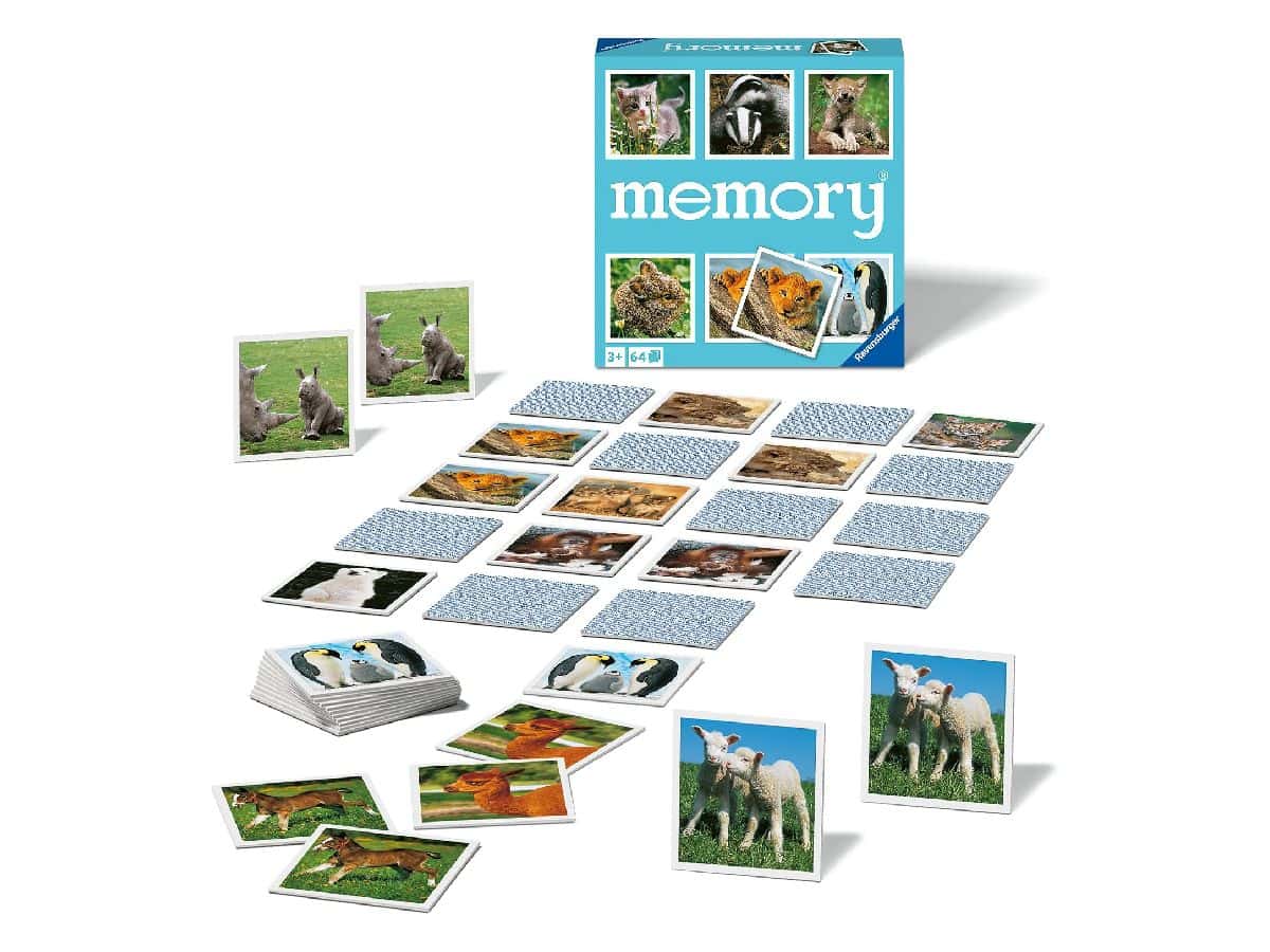 Tessere del Memory Animal Babies capovolte e scoperte sul tavolo, con la scatola e il mazzo di carte